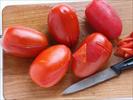 Fate scottare i pomodori in acqua bollente, scolateli, raffreddateli in acqua fredda e privateli della buccia e dei semi.